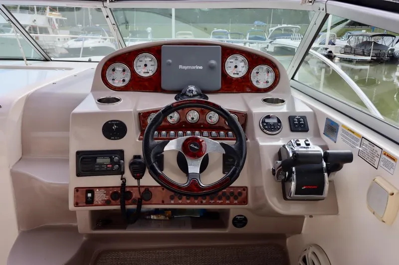 Slide: The Image of 2006 Rinker 360 Express Cruiser helm with steering wheel, gauges, and navigation equipment. - 12