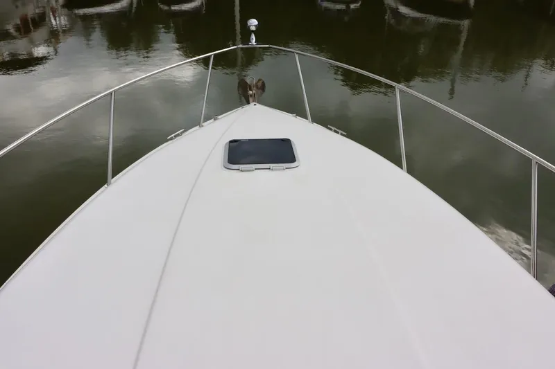 Slide: The Image of Bow view of 2006 Rinker 360 Express Cruiser on calm water. - 14