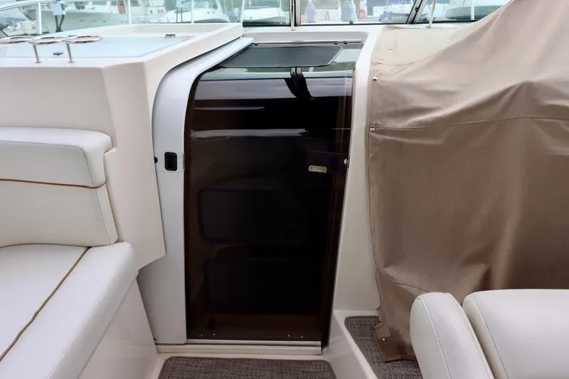 Slide: The Image of 2006 Rinker 360 Express Cruiser interior with white seating and covered console. - 16