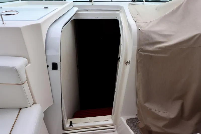 Slide: The Image of 2006 Rinker 360 Express Cruiser cabin entrance with white seating and beige cover. - 17