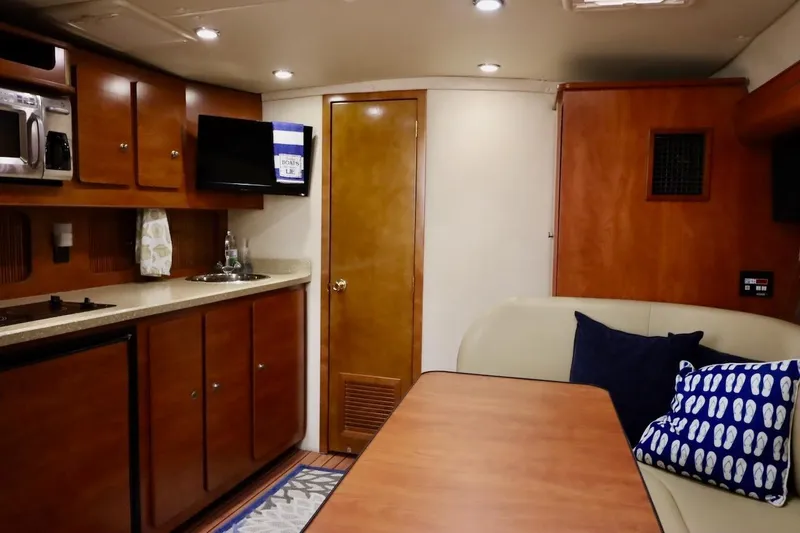 Slide: The Image of 2006 Rinker 360 Express Cruiser interior with kitchenette, seating area, and modern amenities. - 22