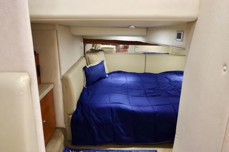 Slide: The Image of Interior cabin of 2006 Rinker 360 Express Cruiser with blue bedding. - 24