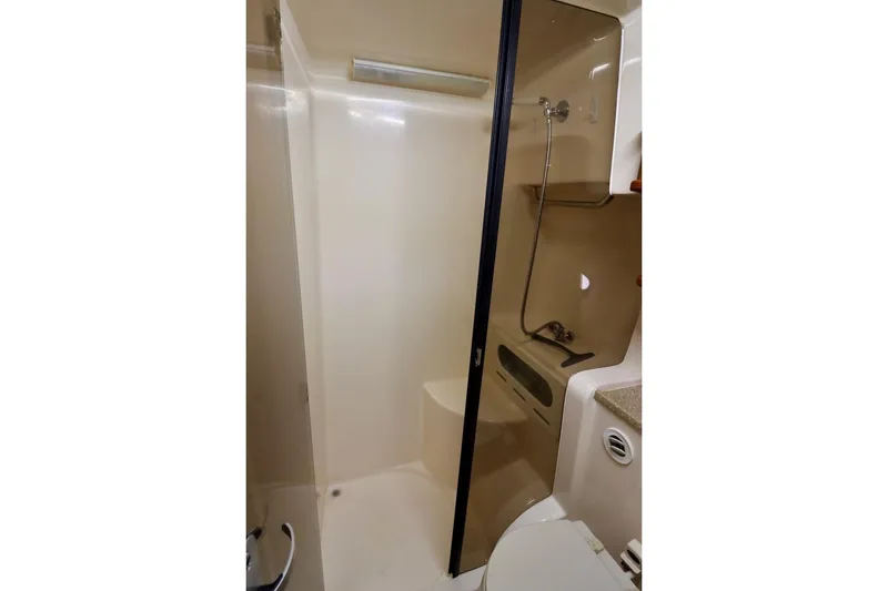 Slide: The Image of 2006 Rinker 360 Express Cruiser bathroom with shower and toilet. - 26