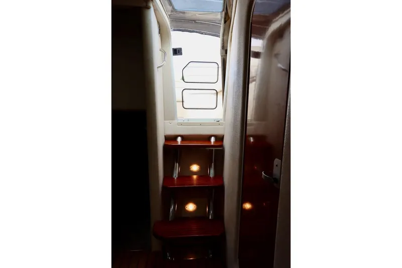 Slide: The Image of Interior stairs of 2006 Rinker 360 Express Cruiser with wooden steps and lighting. - 27