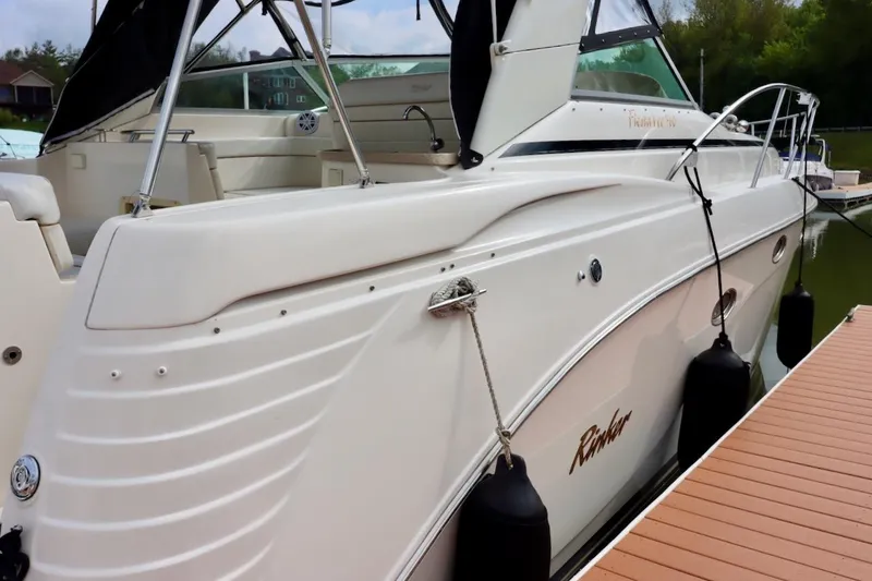 Slide: The Image of 2006 Rinker 360 Express Cruiser docked, showcasing sleek design and spacious deck. - 4