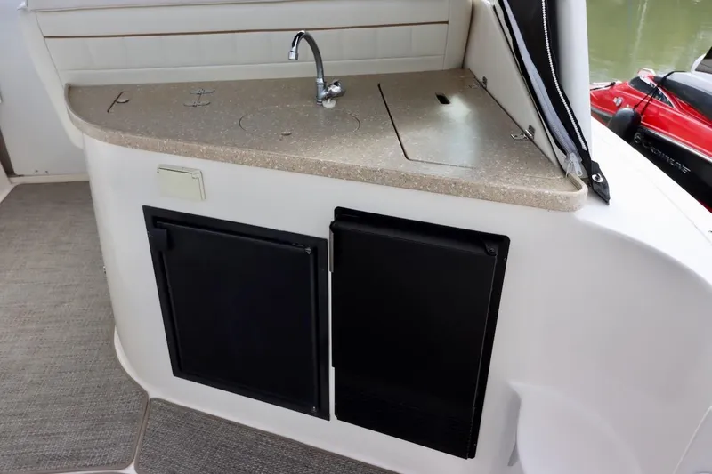 Slide: The Image of 2006 Rinker 360 Express Cruiser kitchenette with sink and storage cabinets. - 7
