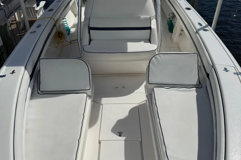 Slide: The Image of 2009 Intrepid 323 boat interior with white cushioned seating and deck. - 10