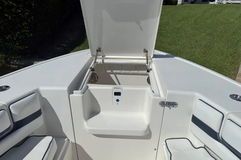Slide: The Image of Open storage compartment on 2009 Intrepid 323 boat, featuring cushioned seating and sleek design. - 12