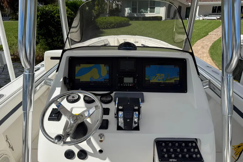 Slide: The Image of 2009 Intrepid 323 boat dashboard with navigation screens and steering wheel. - 2