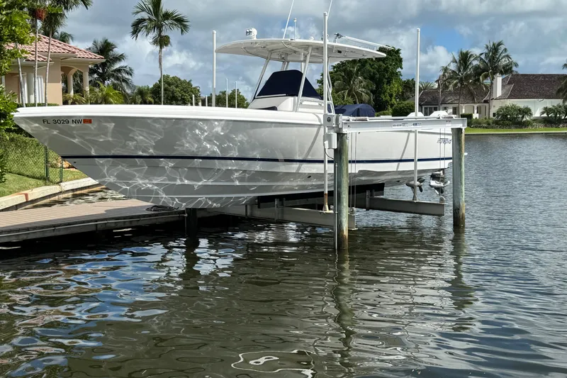 Slide: The Image of 2009 Intrepid 323 boat docked on a lift by a waterfront home. - 8