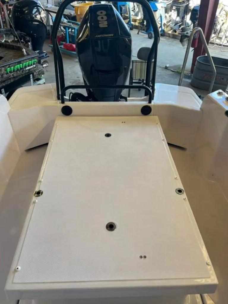 Slide: The Image of 2023 Axopar 22 T-Top boat interior with outboard motor in a workshop. - 10