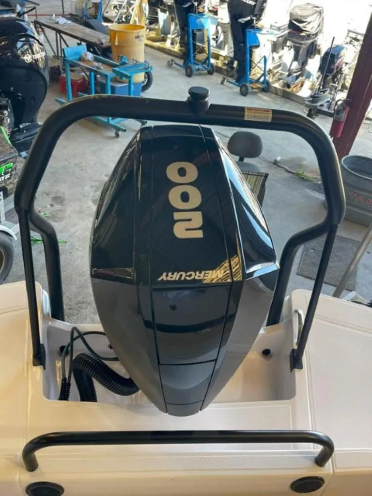 Slide: The Image of 2023 Axopar 22 T-Top with Mercury 200 outboard engine in a workshop. - 11