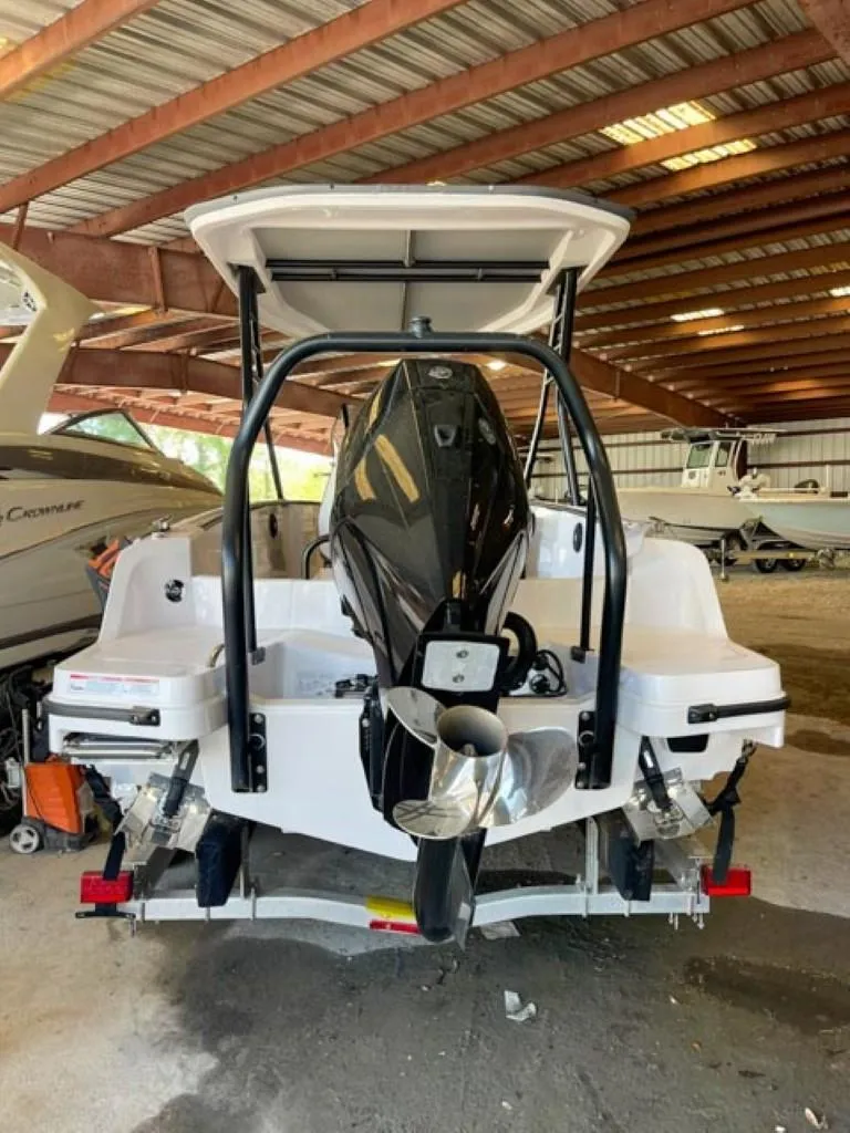 Slide: The Image of 2023 Axopar 22 T-Top boat with outboard motor in covered storage. - 3