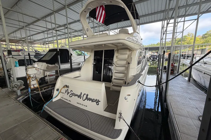 Slide: The Image of 2004 Meridian 341 Sedan yacht docked in marina, rear view with American flag. - 12