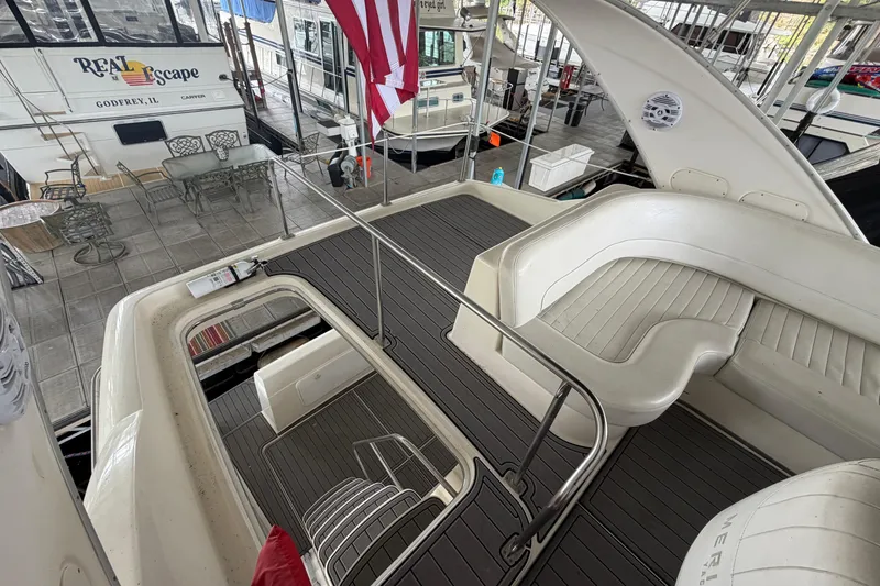 Slide: The Image of 2004 Meridian 341 Sedan yacht interior with seating and deck, docked near other boats. - 18
