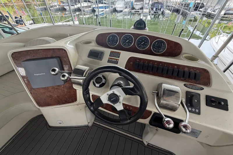 Slide: The Image of 2004 Meridian 341 Sedan boat helm with steering wheel and control panel. - 19