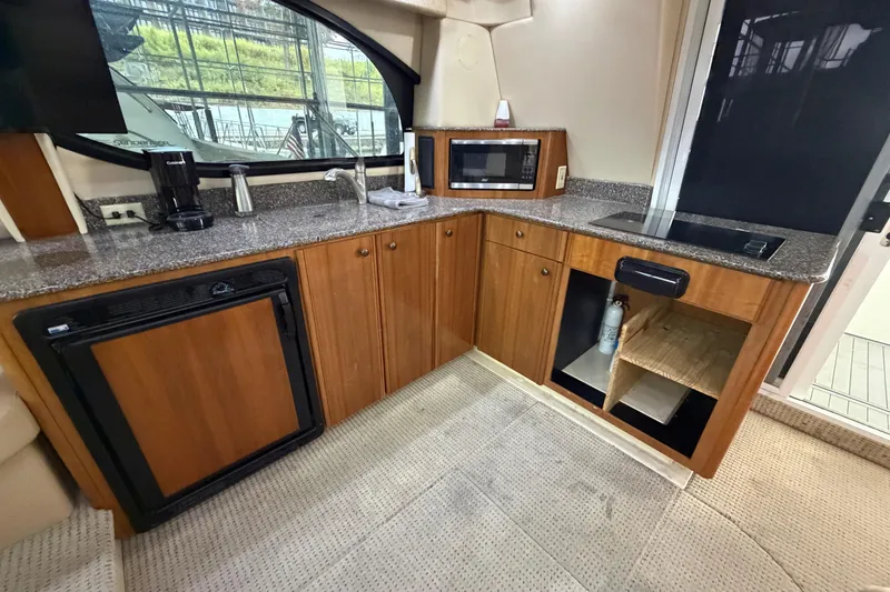 Slide: The Image of 2004 Meridian 341 Sedan yacht kitchen with wood cabinets, granite countertops, and modern appliances. - 27