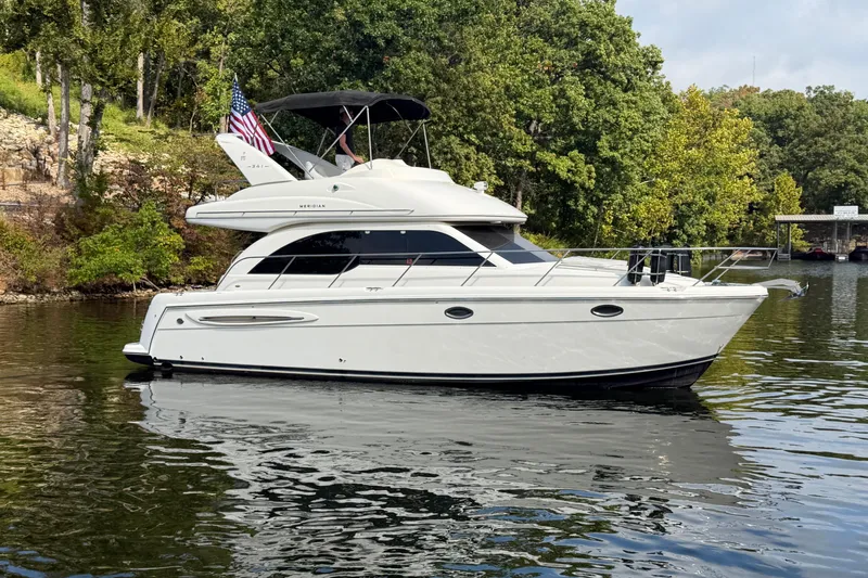 Slide: The Image of 2004 Meridian 341 Sedan yacht on a serene lake with lush green trees. - 8