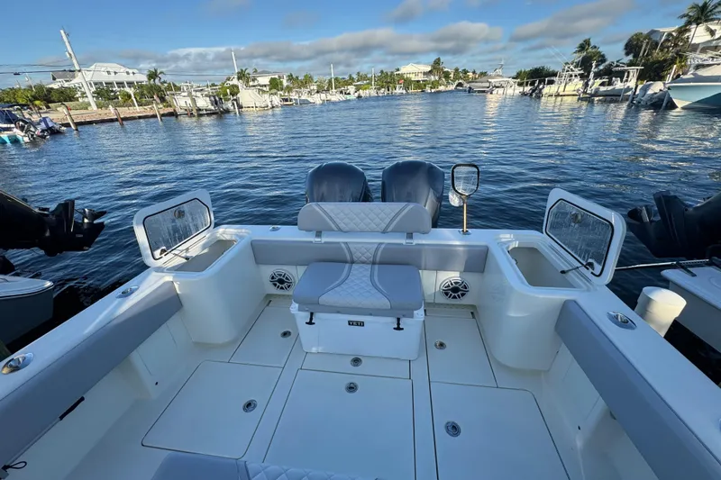 Slide: The Image of 2022 SeaVee 322 Z boat interior with dual engines, docked in a marina. - 13