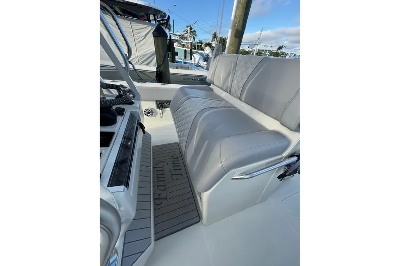 Slide: The Image of 2022 SeaVee 322 Z boat interior with gray seating and "Family Time" mat. - 18