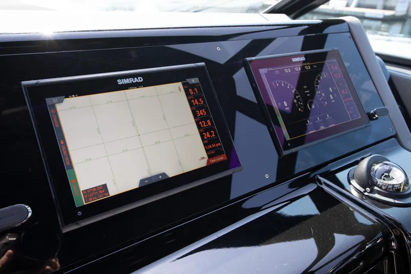 Slide: The Image of 2024 Cruisers Yachts 38 GLS OB dashboard with dual Simrad displays and compass. - 10