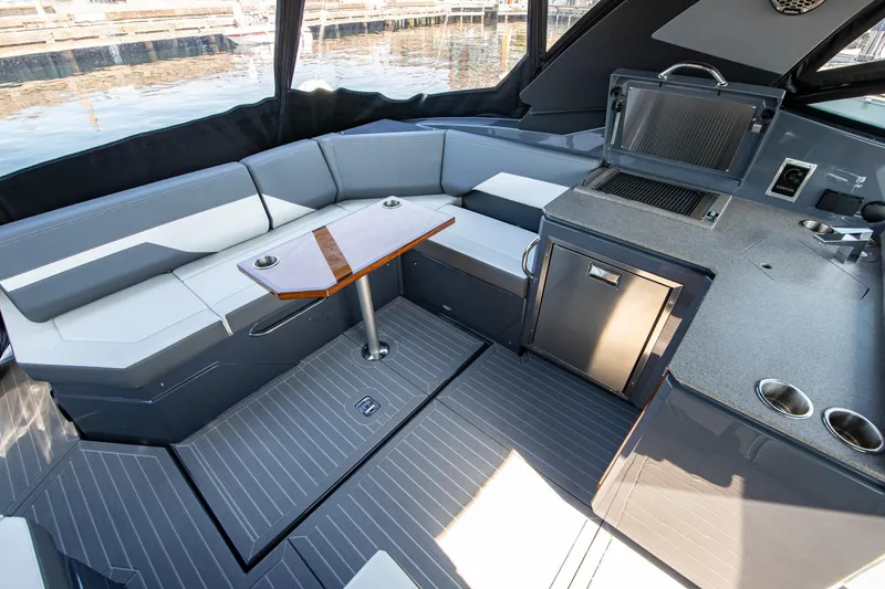 Slide: The Image of 2024 Cruisers Yachts 38 GLS OB interior with seating, table, and kitchenette. - 13