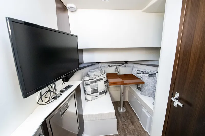 Slide: The Image of 2024 Cruisers Yachts 38 GLS OB interior with cozy seating, TV, and modern decor. - 16