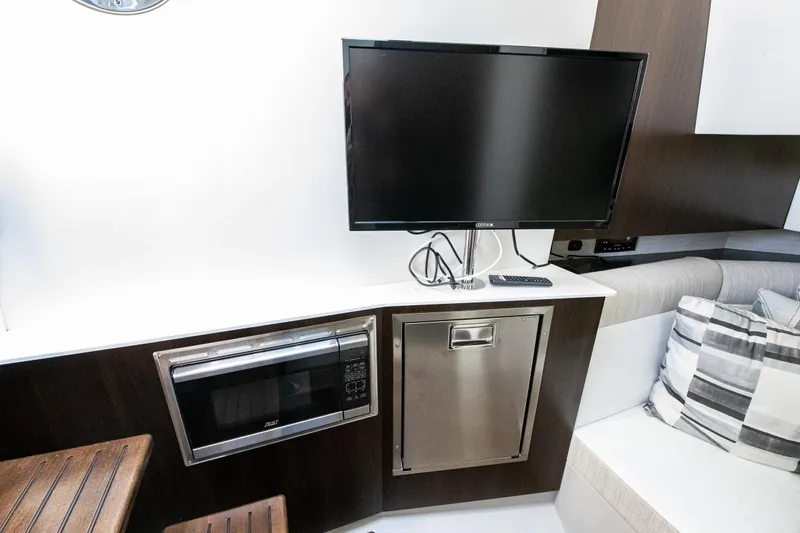 Slide: The Image of 2024 Cruisers Yachts 38 GLS OB interior with TV, microwave, and seating area. - 17