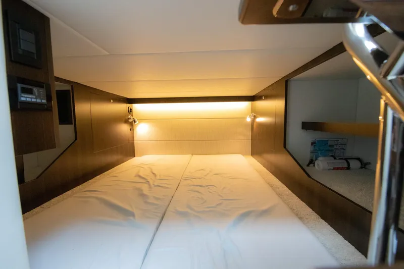 Slide: The Image of 2024 Cruisers Yachts 38 GLS OB cabin interior with cozy bed and ambient lighting. - 20