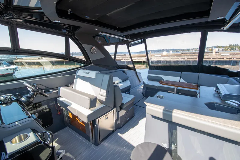 Slide: The Image of 2024 Cruisers Yachts 38 GLS OB interior with modern seating and helm, dockside view. - 22