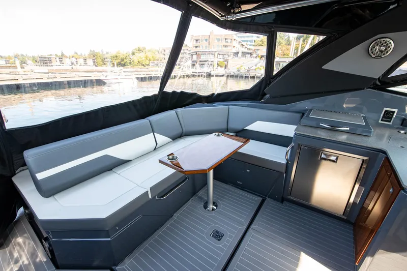 Slide: The Image of 2024 Cruisers Yachts 38 GLS OB interior with seating and table, dockside view. - 3