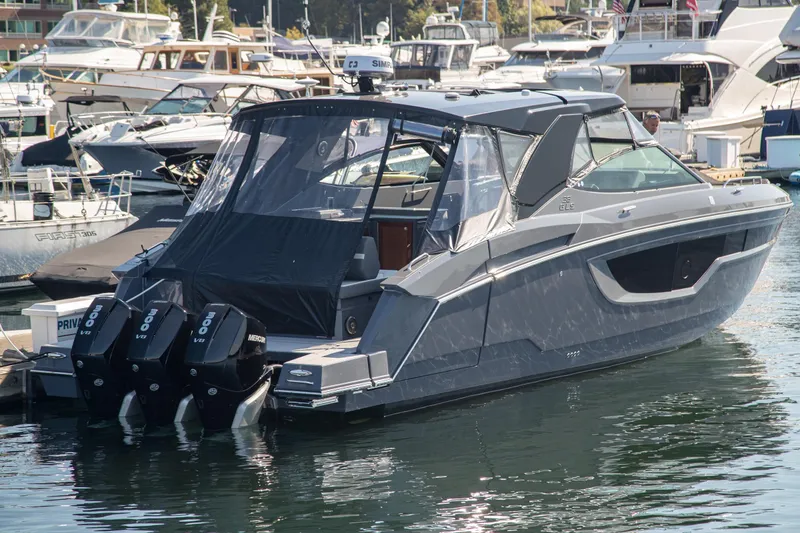Slide: The Image of 2024 Cruisers Yachts 38 GLS OB in marina, featuring triple Mercury outboard engines. - 33
