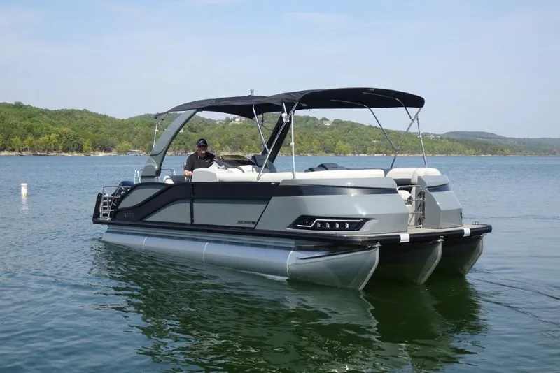The Image of 2026 Harris Grand Mariner 250 pontoon boat on a serene lake. - 0