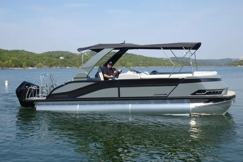 Slide: The Image of 2026 Harris Grand Mariner 250 pontoon boat on a serene lake. - 1