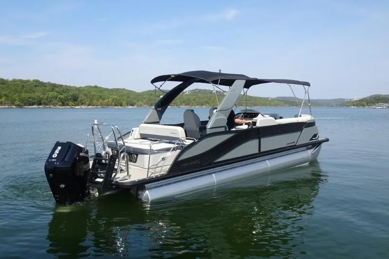Slide: The Image of 2026 Harris Grand Mariner 250 pontoon boat on a serene lake. - 2