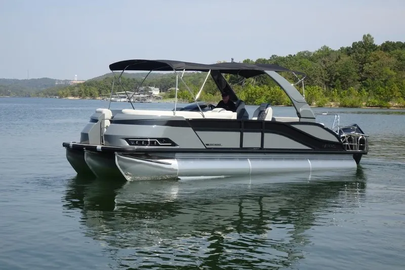 Slide: The Image of 2026 Harris Grand Mariner 250 pontoon boat cruising on a serene lake. - 5