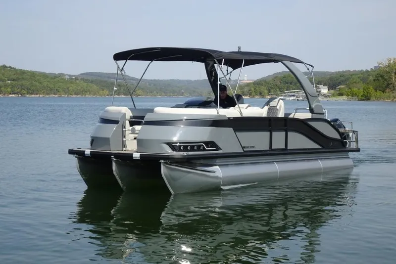 Slide: The Image of 2026 Harris Grand Mariner 250 pontoon boat on a serene lake. - 6
