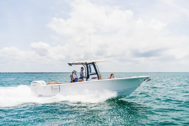 Slide: The Image of 2026 Sea Hunt Ultra 265 SE cruising on open water under a clear sky. - 2