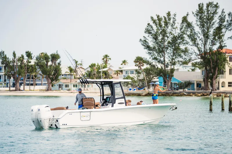 Slide: The Image of 2026 Sea Hunt Ultra 265 SE boat on water, people fishing, coastal background. - 7