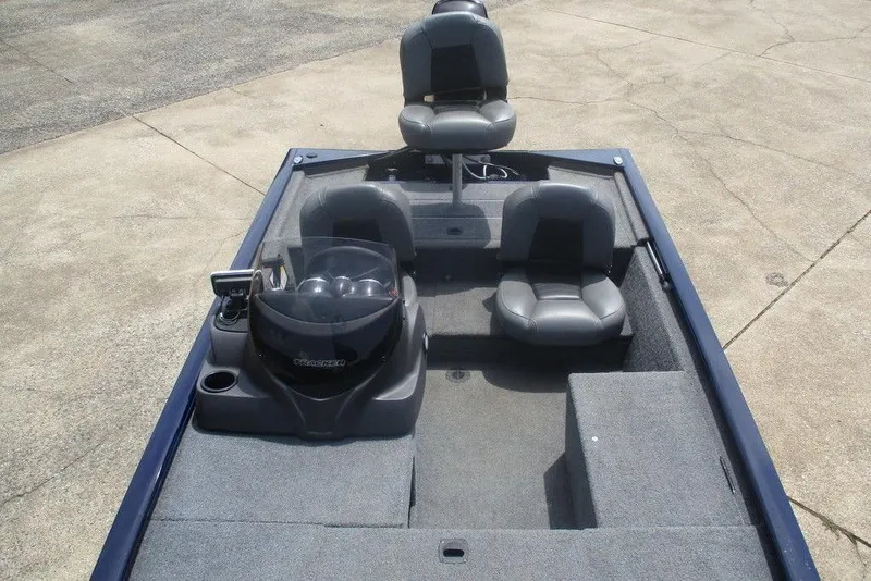 Slide: The Image of 2022 Tracker Pro 170 boat interior with seating and console on concrete surface. - 6