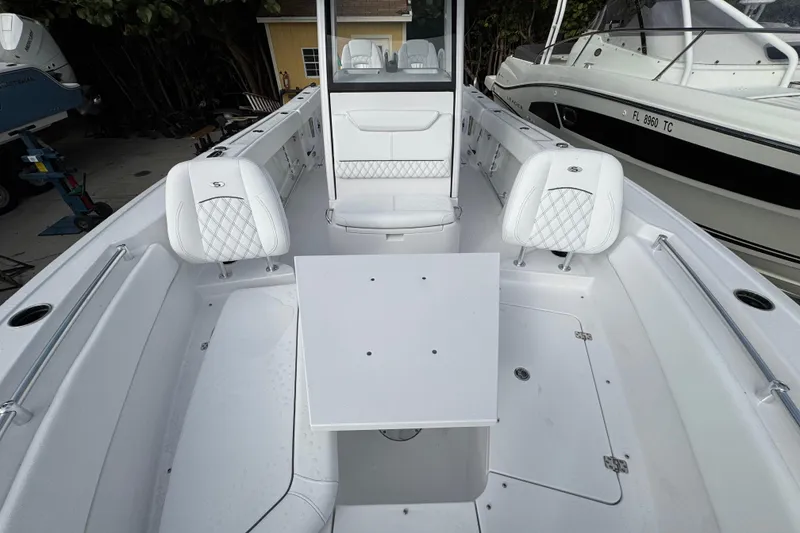 Slide: The Image of 2026 Sportsman Heritage 261 Center Console boat interior with white seating and table. - 14