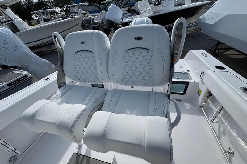 Slide: The Image of 2026 Sportsman Heritage 231 Center Console boat seats with white upholstery and diamond stitching. - 11