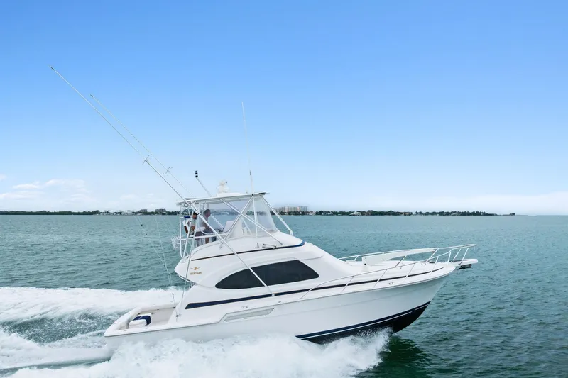 The Image of 2006 Bertram 39 Convertible yacht cruising on open water under clear blue sky. - 1