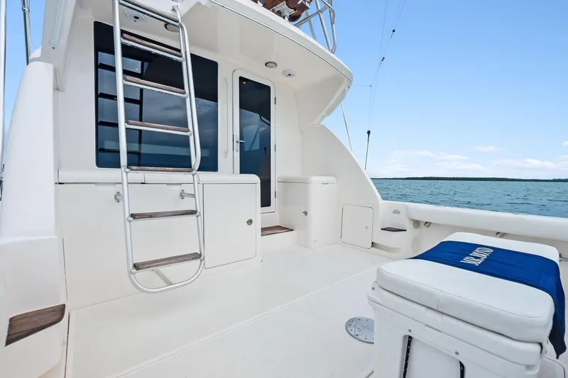 Slide: The Image of 2006 Bertram 39 Convertible yacht deck with ladder, ocean view, and seating area. - 23