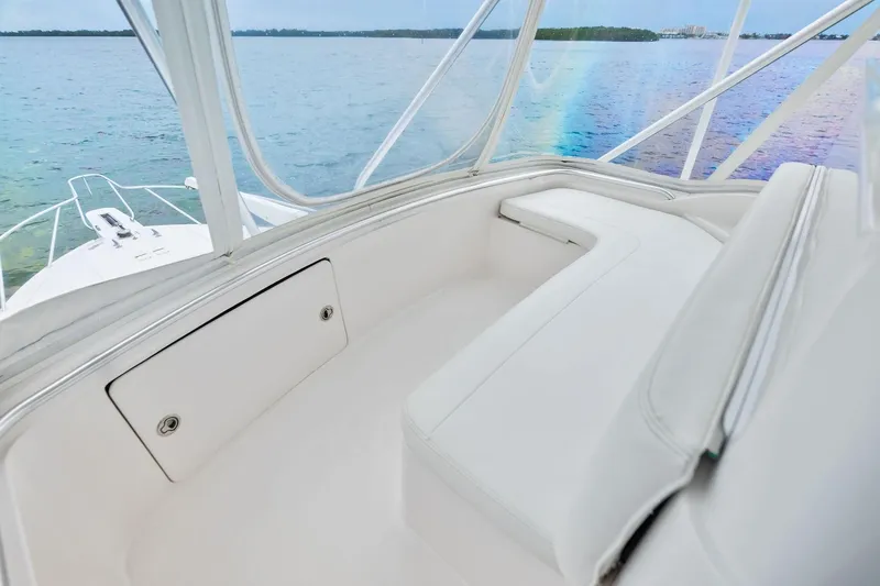 Slide: The Image of 2006 Bertram 39 Convertible boat interior with white seating, overlooking calm waters. - 33
