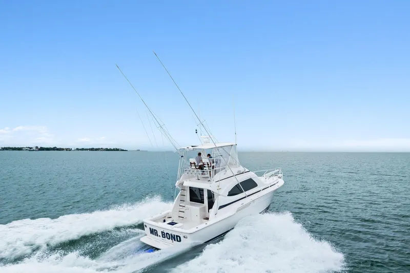 Slide: The Image of 2006 Bertram 39 Convertible yacht cruising on open water under clear blue sky. - 7