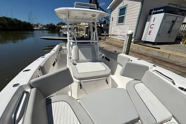 Slide: The Image of 2023 Sea Fox 268 Commander boat with spacious seating, docked near a waterfront building. - 37