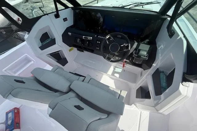Slide: The Image of Interior view of 2025 Axopar 29 Sun Top boat with modern dashboard and seating. - 2