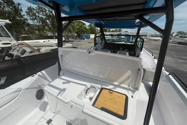Slide: The Image of 2025 Axopar 29 Sun Top boat interior with open storage and cutting board. - 4