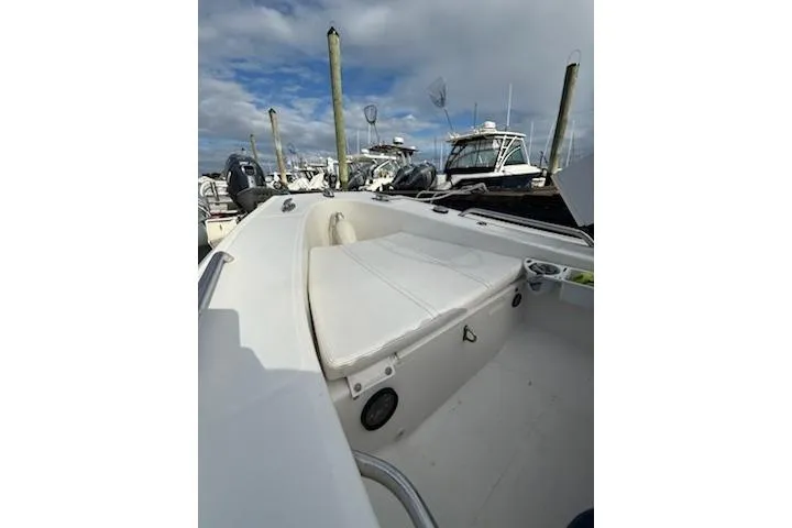 Slide: The Image of 2011 Rigid Boats 10.4 Sport with cushioned seating, docked at marina under cloudy sky. - 3
